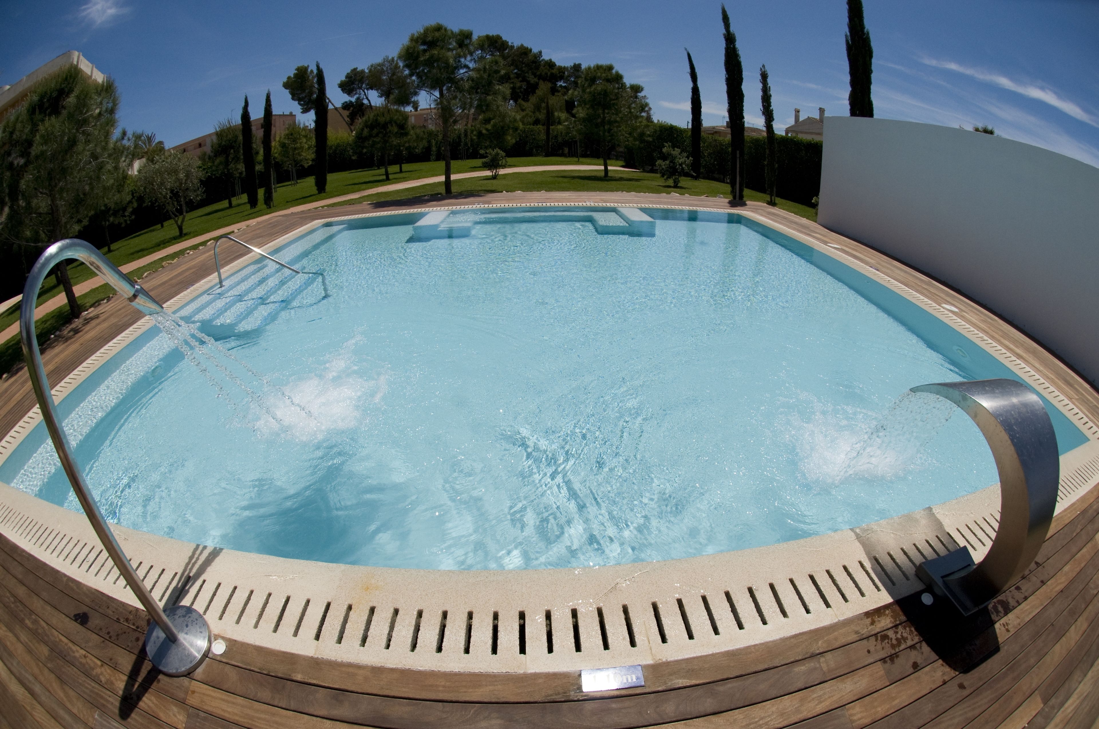 Una piscina con cubierta de madera y barandales de metal.