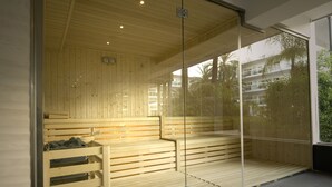 Una sauna con bancos de madera y una pared de vidrio.