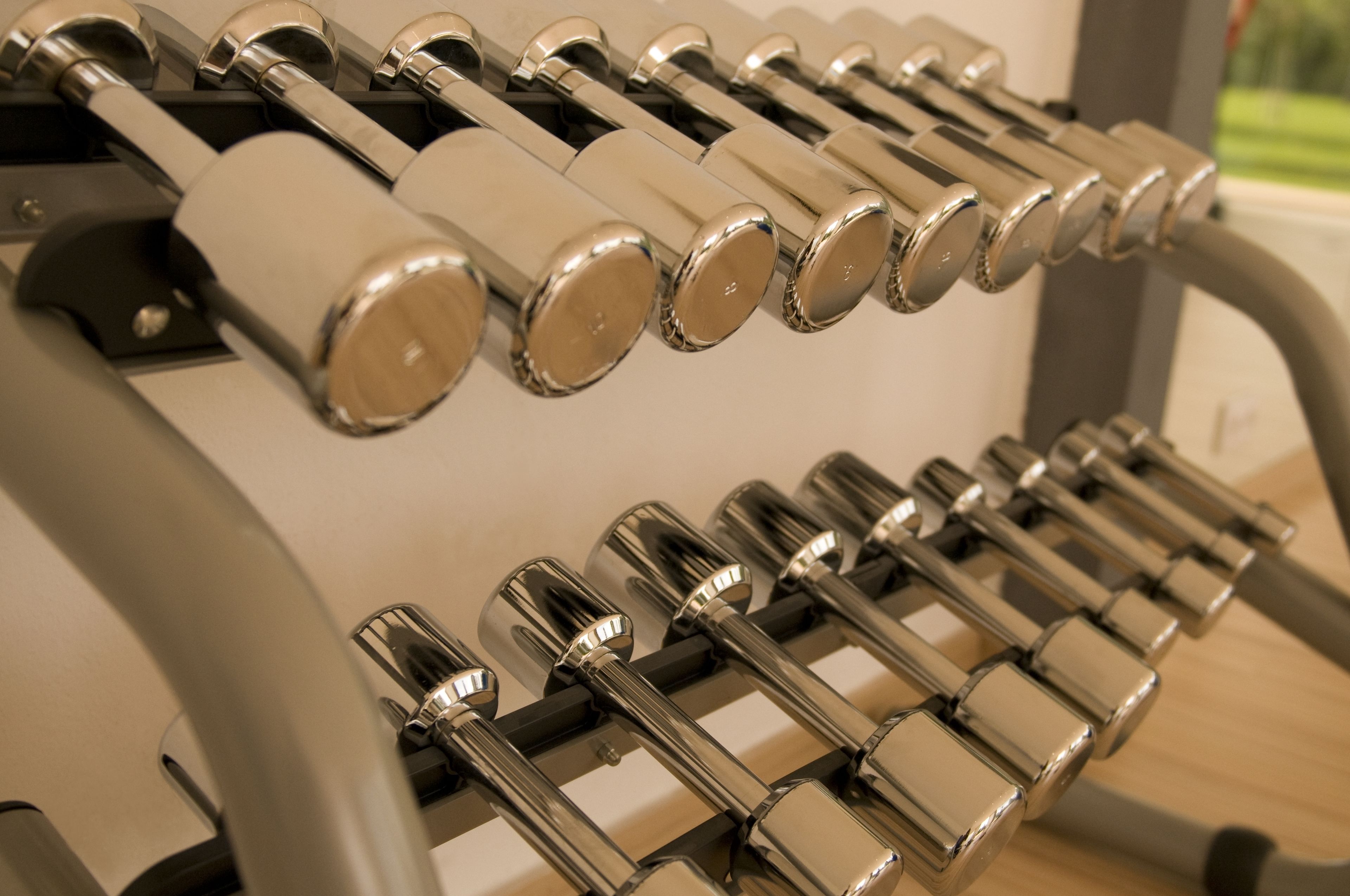A row of metallic, cylindrical objects with a reflective surface, likely part of a piece of equipment or furniture.