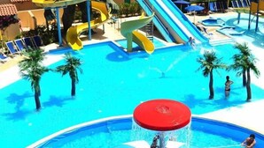 A water park with slides, a large water feature, and palm trees. - La Jacia Hotel & Resort (Arzachena)