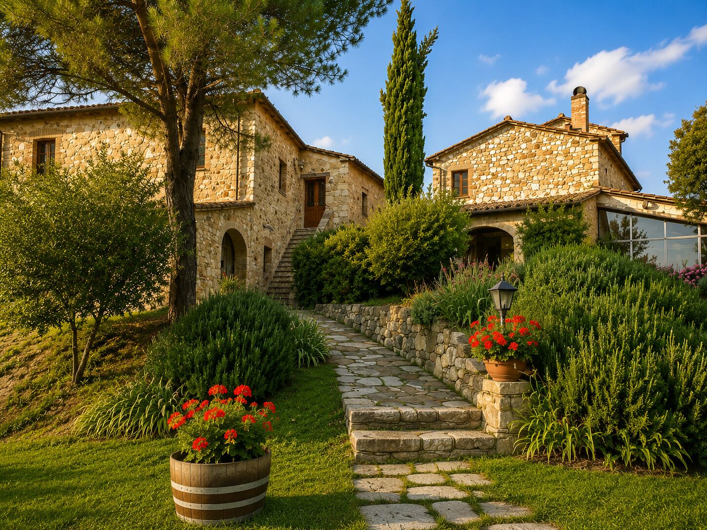 Un edificio in pietra con una scala che conduce a una porta, immerso nel verde e circondato da piante fiorite.