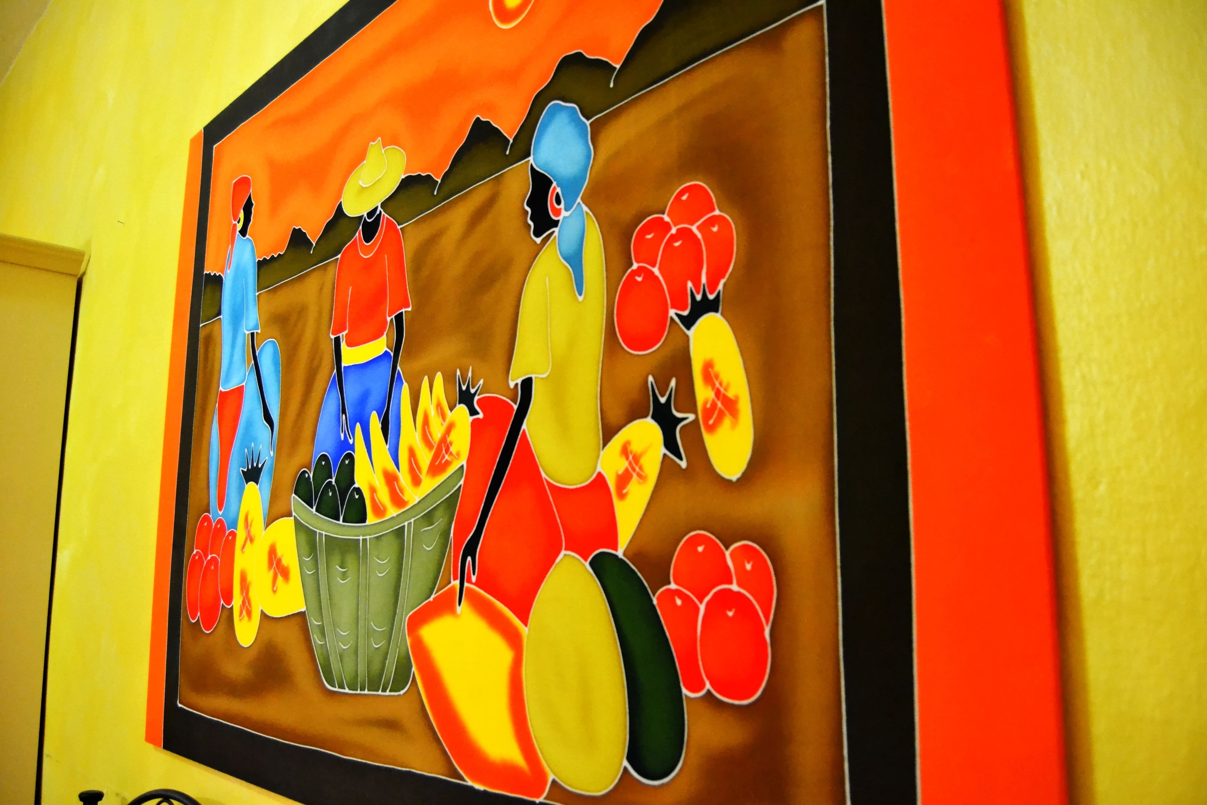 A colorful mural with figures and fruits.