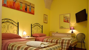 A room with two beds, a nightstand with a lamp, a dresser, a chair, and a painting on the wall. - La Corte Bed & Breakfast (Lecce)