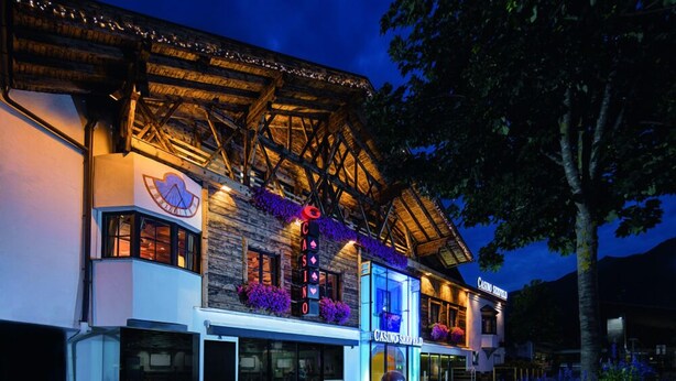 A building with a casino sign, outdoor seating, and a stone facade. - Vergeiner (Seefeld in Tirol)