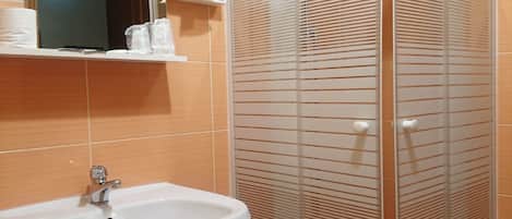 Une salle de bain avec une douche à parois de verre, un lavabo et des toilettes.