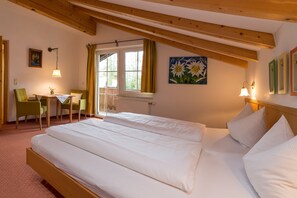 A bedroom with two beds, a desk, and a chair.