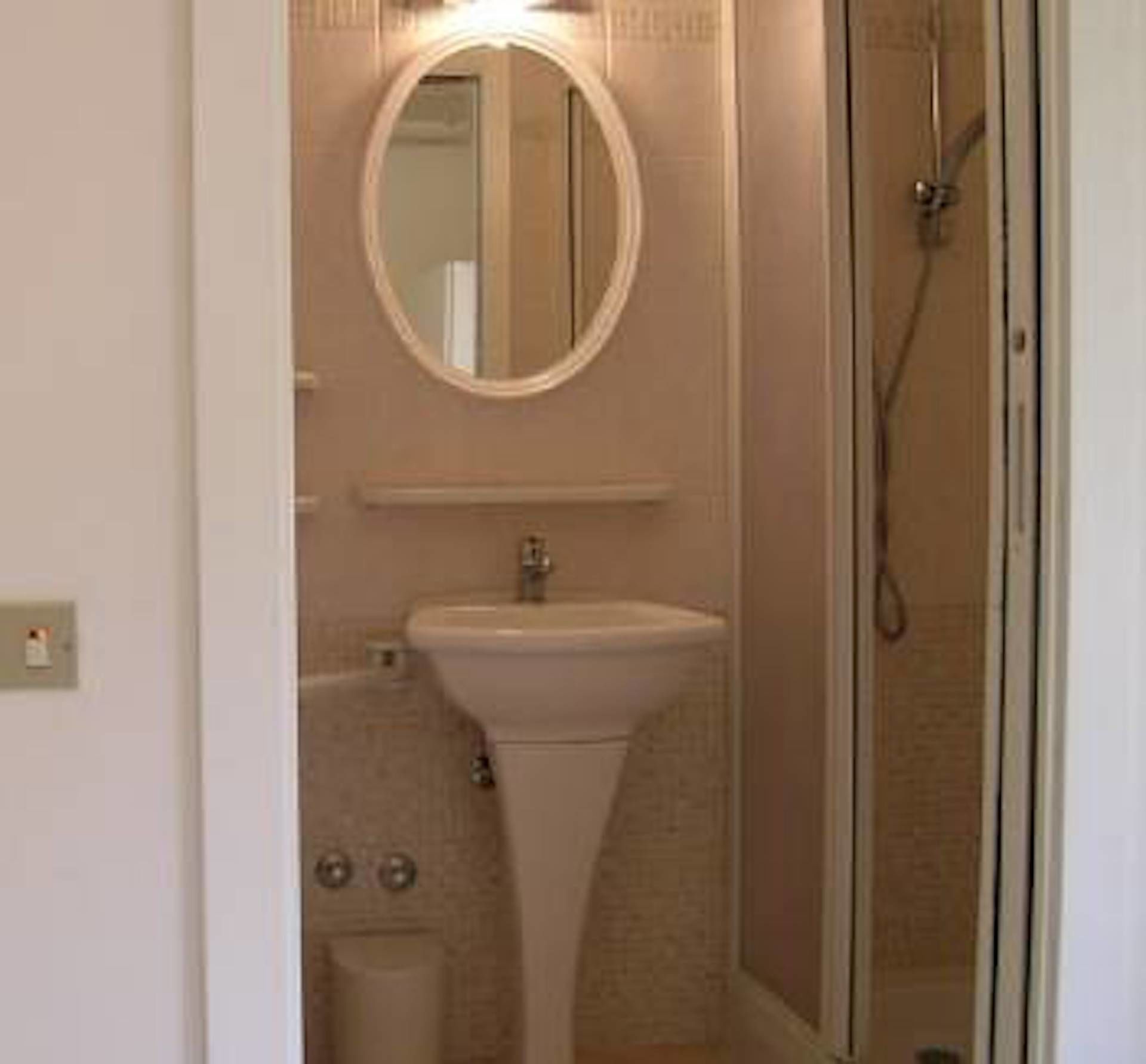 Une salle de bain avec un lavabo, un miroir et une douche.