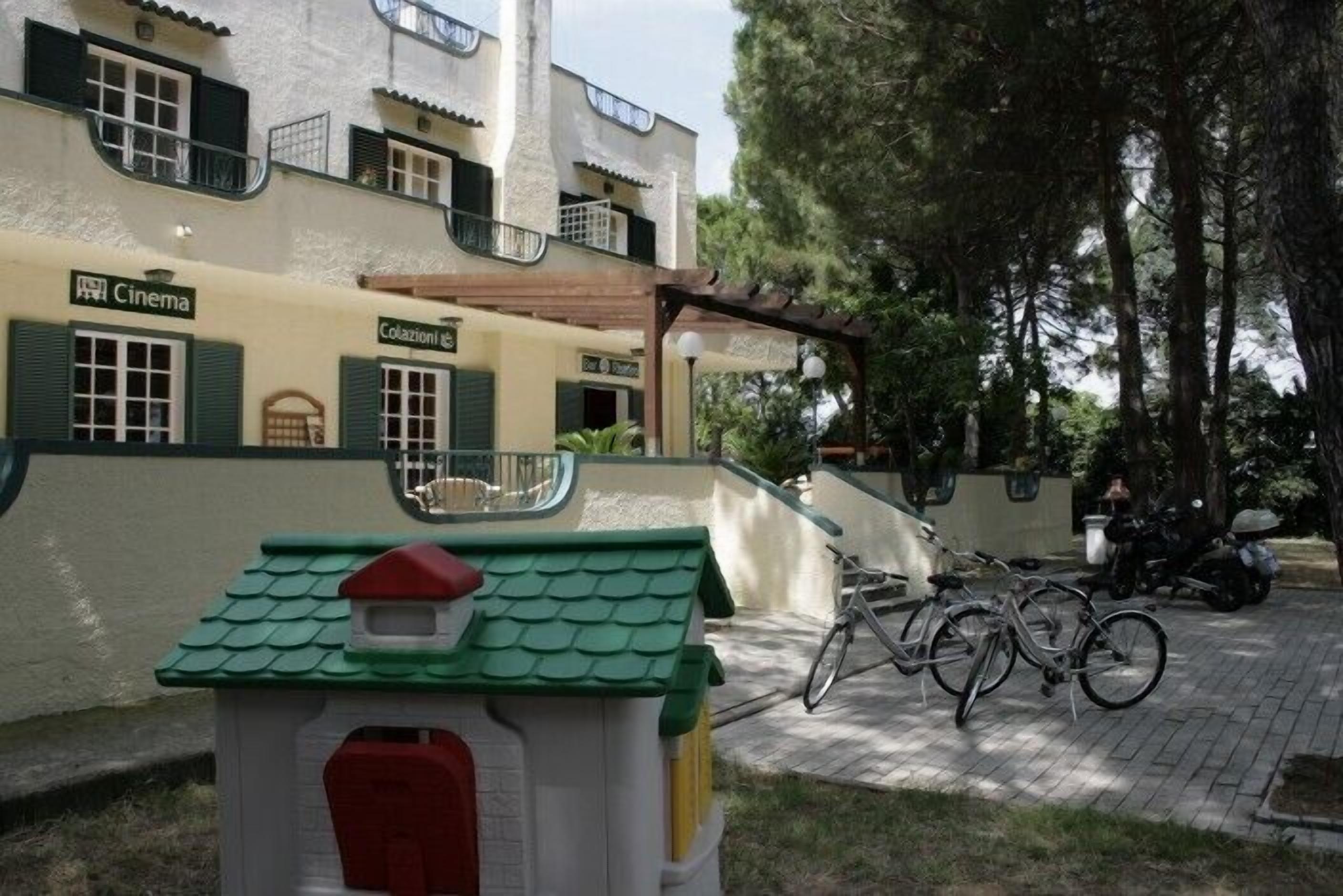A building with a cinema and a restaurant. There are bicycles parked outside.