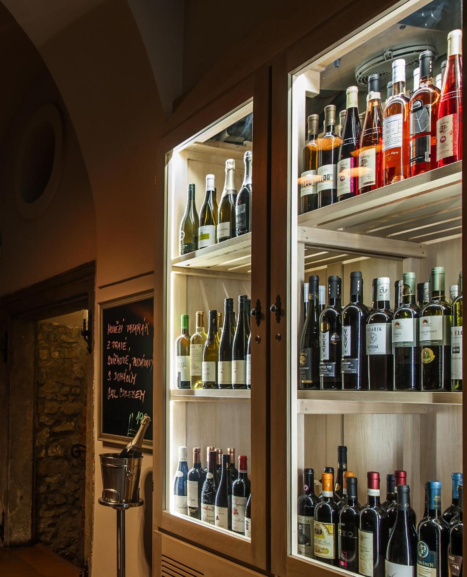 A wine cellar with a variety of bottles on shelves.