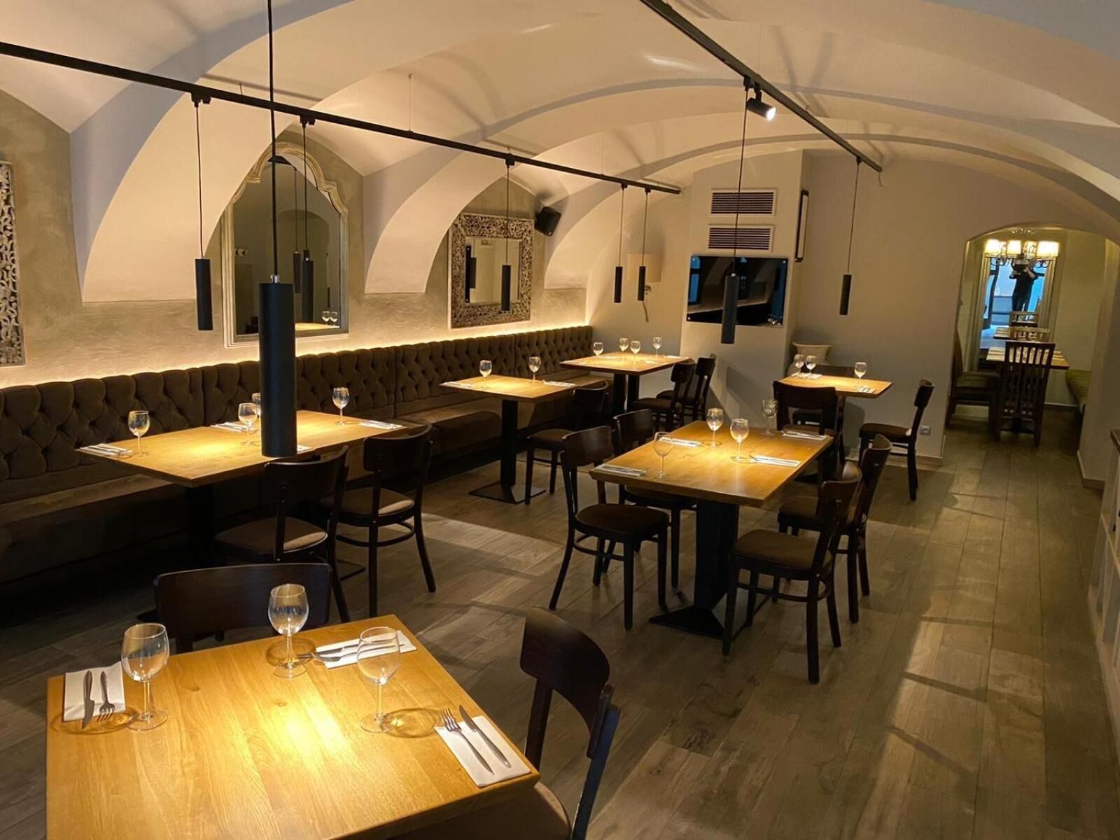 A restaurant with high arched ceilings, wooden tables, and cushioned seating.