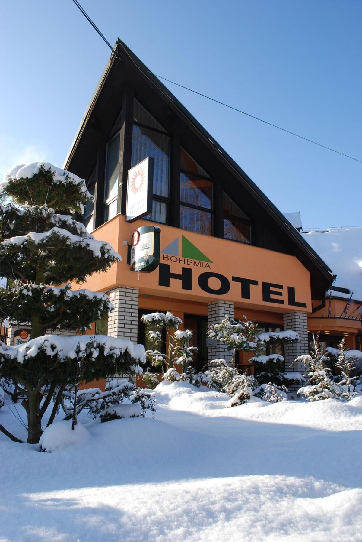 Un hotel con un cartel llamativo que dice "BOHEMIA HOTEL" y un logotipo sobre la entrada.