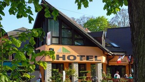 Un hotel de diseño moderno, con un cartel llamativo, un jardín cuidado y una entrada acogedora.