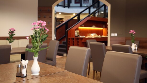 Un restaurante con una decoración moderna, que incluye una escalera, mesas y sillas.