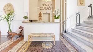 A reception area with a bench, a staircase, and a wall with 'VILLA CLAUDIA' written on it. - Villa Claudia Hotel Cannes Centre - Parking (Cannes)