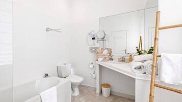 A modern bathroom with a bathtub, toilet, and sink.