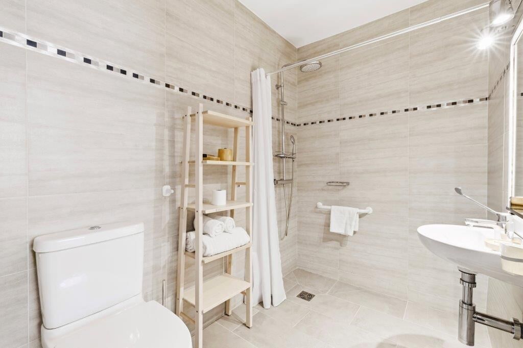 Un baño moderno con inodoro, ducha y lavamanos.