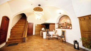Un interior espacioso con una escalera de madera, una chimenea y un comedor con sillas.