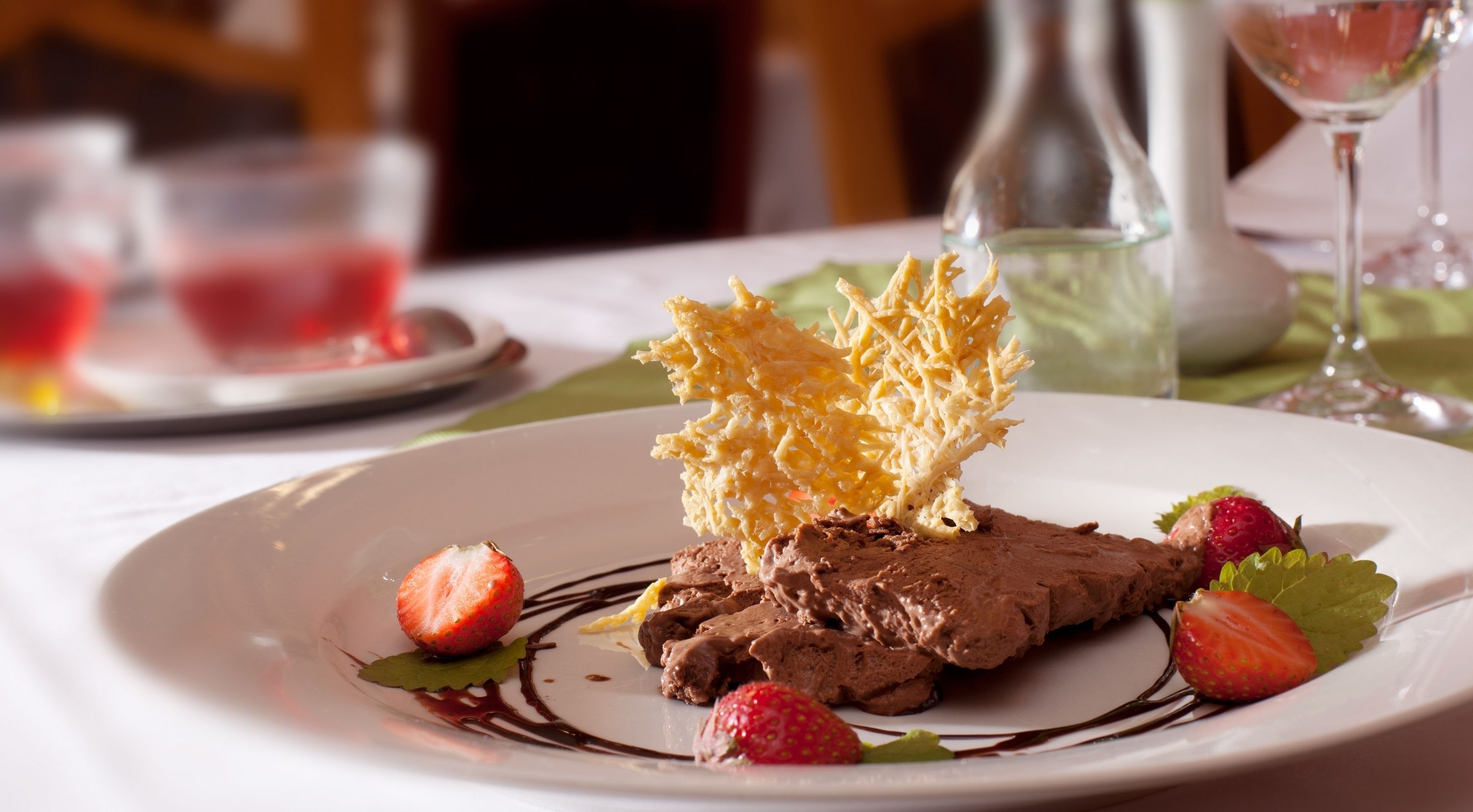 Een dessertbord met chocolademousse, aardbeien en een knapperige topping.