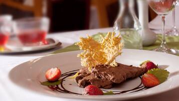 Een dessertbord met chocolademousse, aardbeien en een knapperige topping.