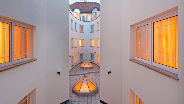 En korridor med flera fönster och en central innergård med en lampa.