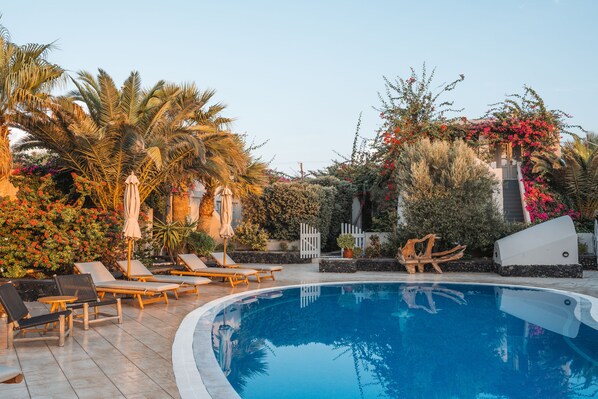 Alberca al aire libre y camastros 