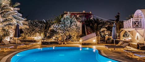 Una piscina al aire libre, tumbonas