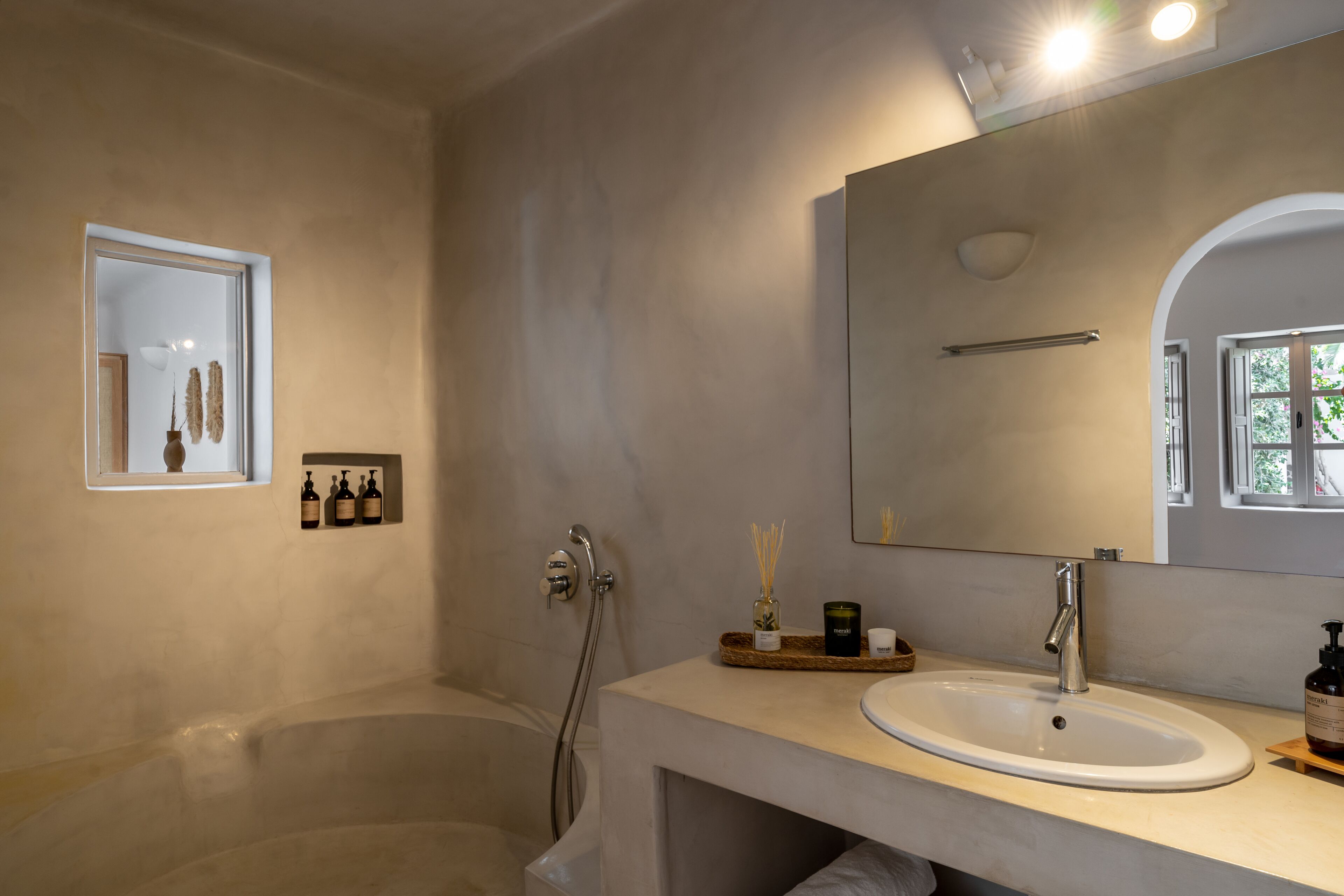 Un baño moderno con una bañera, un espejo grande y un lavamanos.