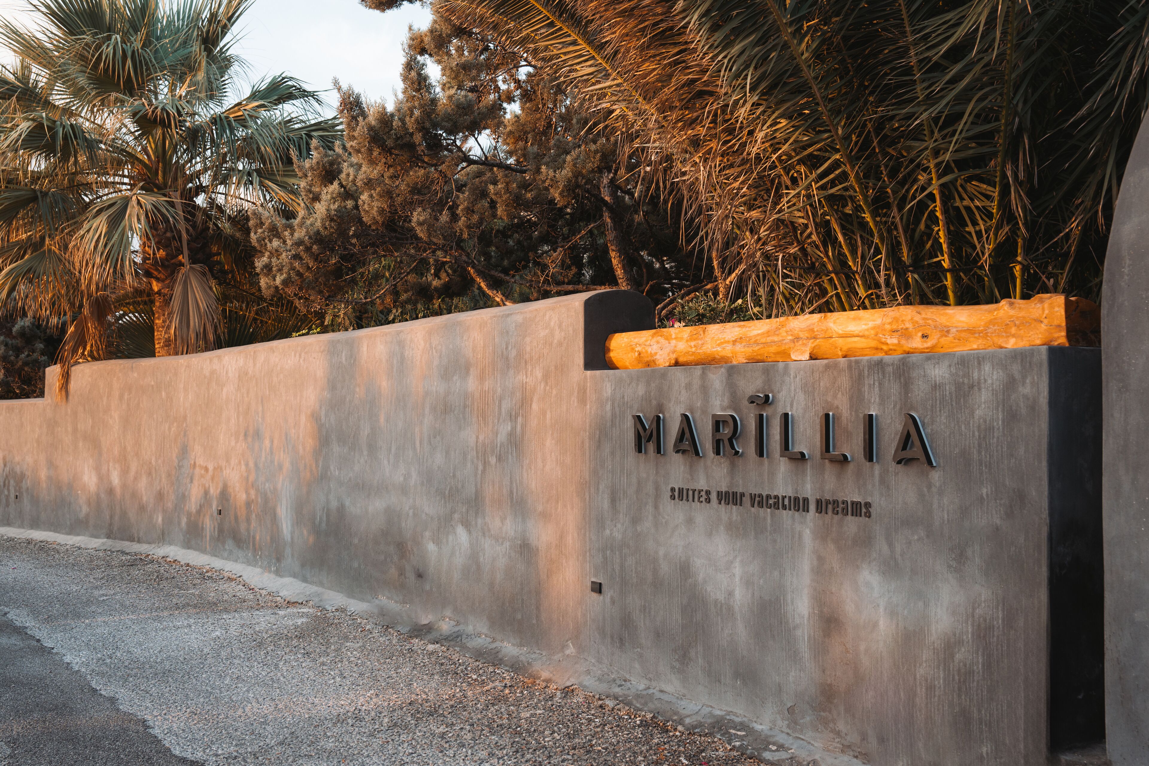 Pared de concreto con el nombre "MARILLIA" y la frase "SUITES YOUR VISION DREAMS" grabado en él.