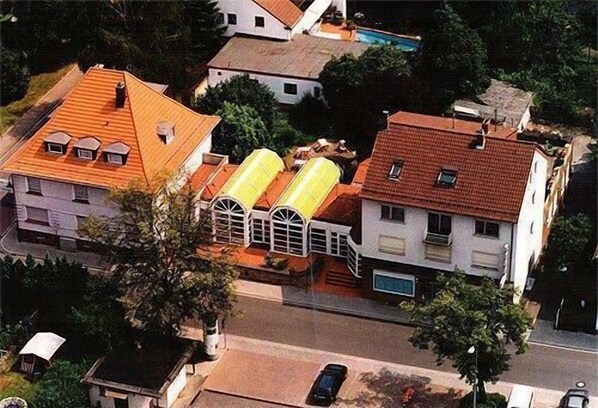Vista aérea de um bairro residencial com casas, piscina e rua.