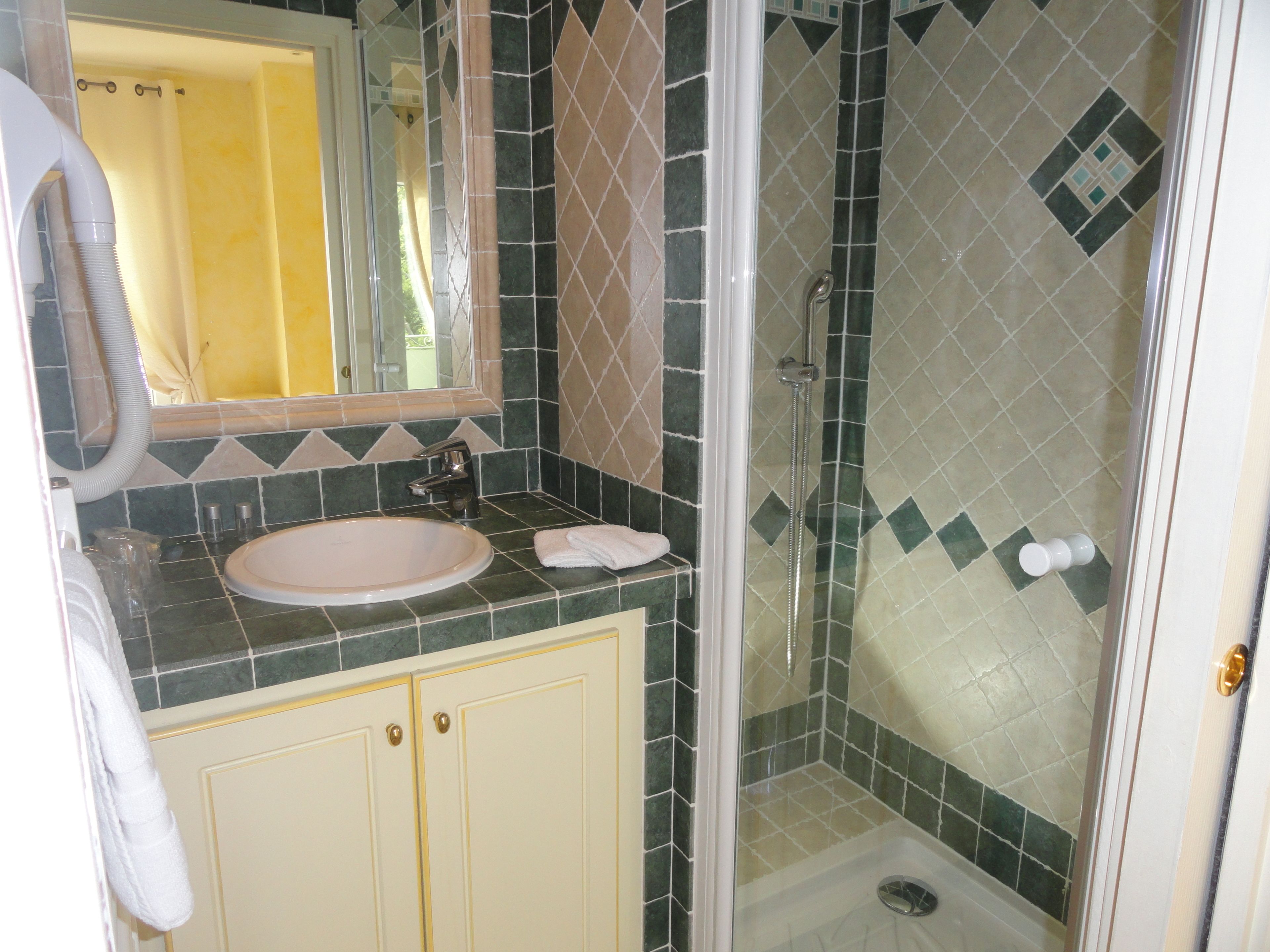 Un baño con lavamanos, espejo y ducha.