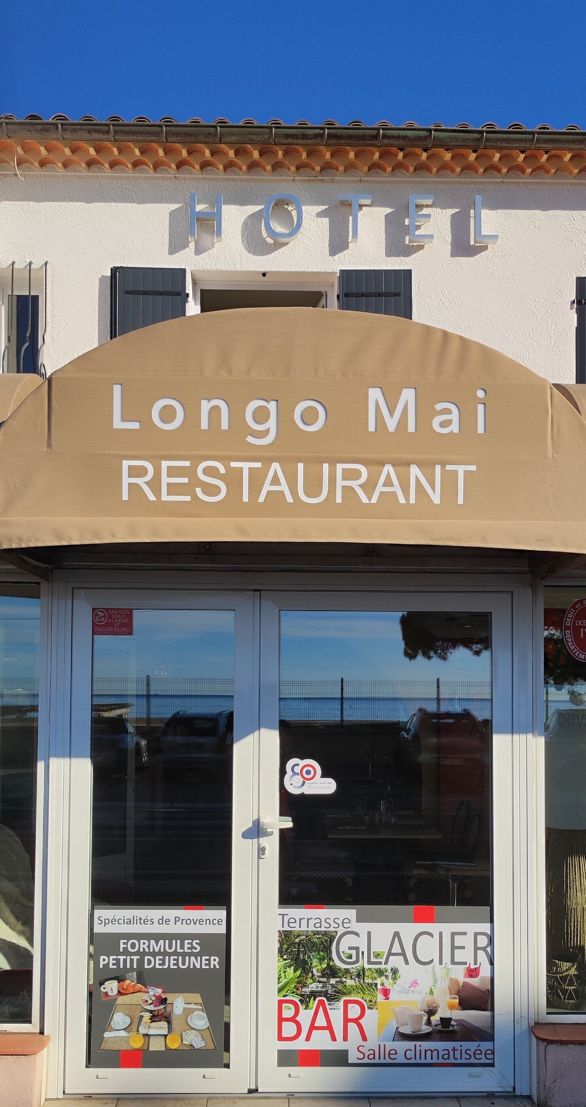 Un albergo con un cartello sopra l'ingresso che riporta 'Longo Mai Restaurant'.