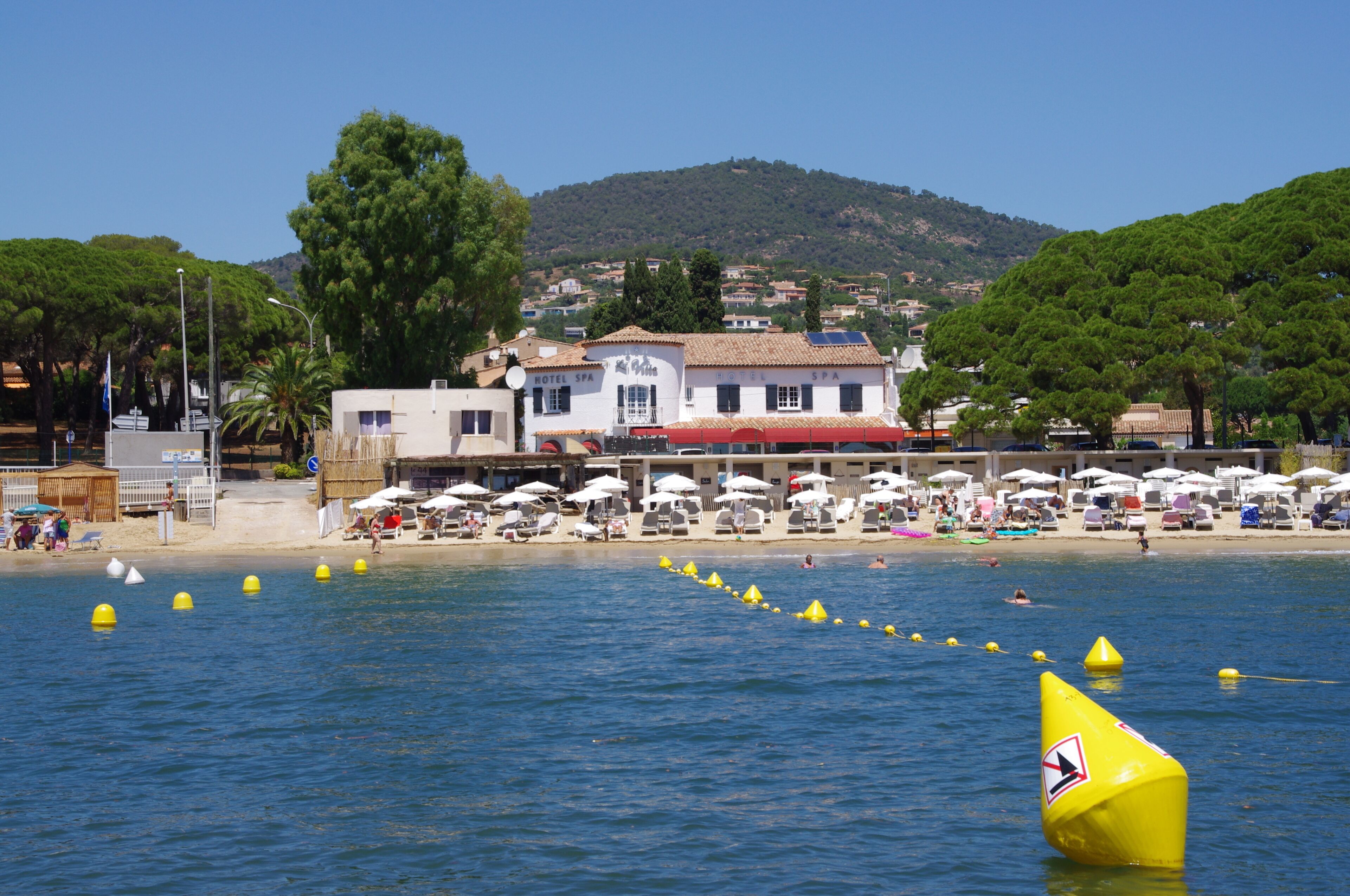 A coastal hotel with a beach view, multiple rooms, and a swimming area.