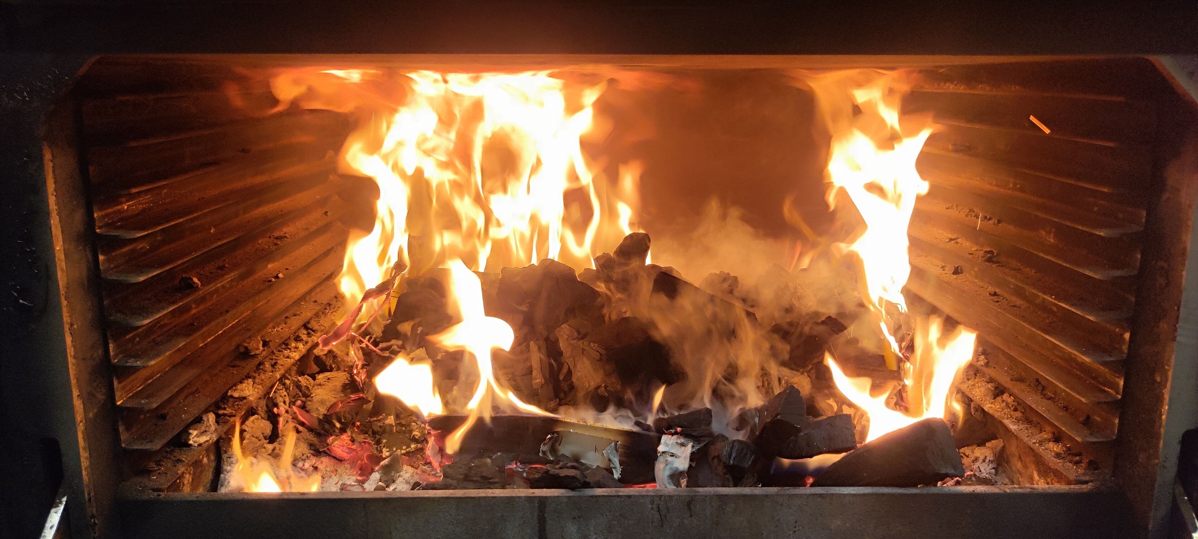 Una chimenea con leña ardiendo y llamas.