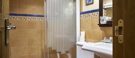 A bathroom with a shower, toilet, and sink.