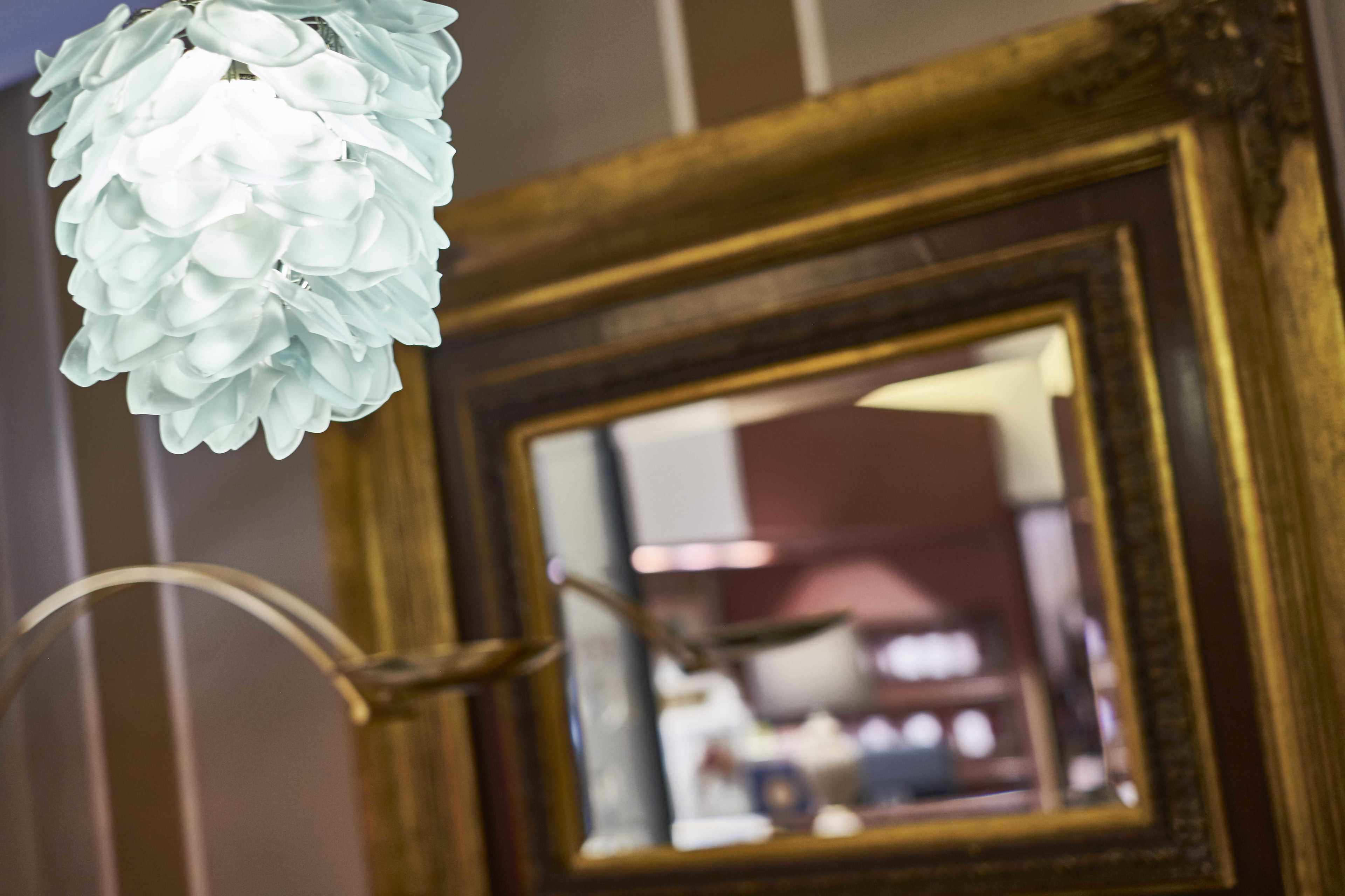 A framed mirror with a reflection of a room interior.