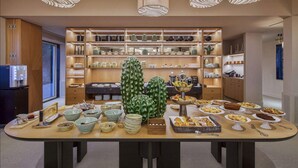 Una mesa de buffet con diversos platos y una extensa exhibición de cactus verdes.