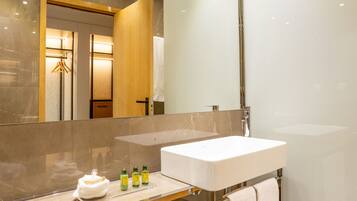 Un baño moderno con un espejo grande, un lavabo blanco y una zona de ducha.