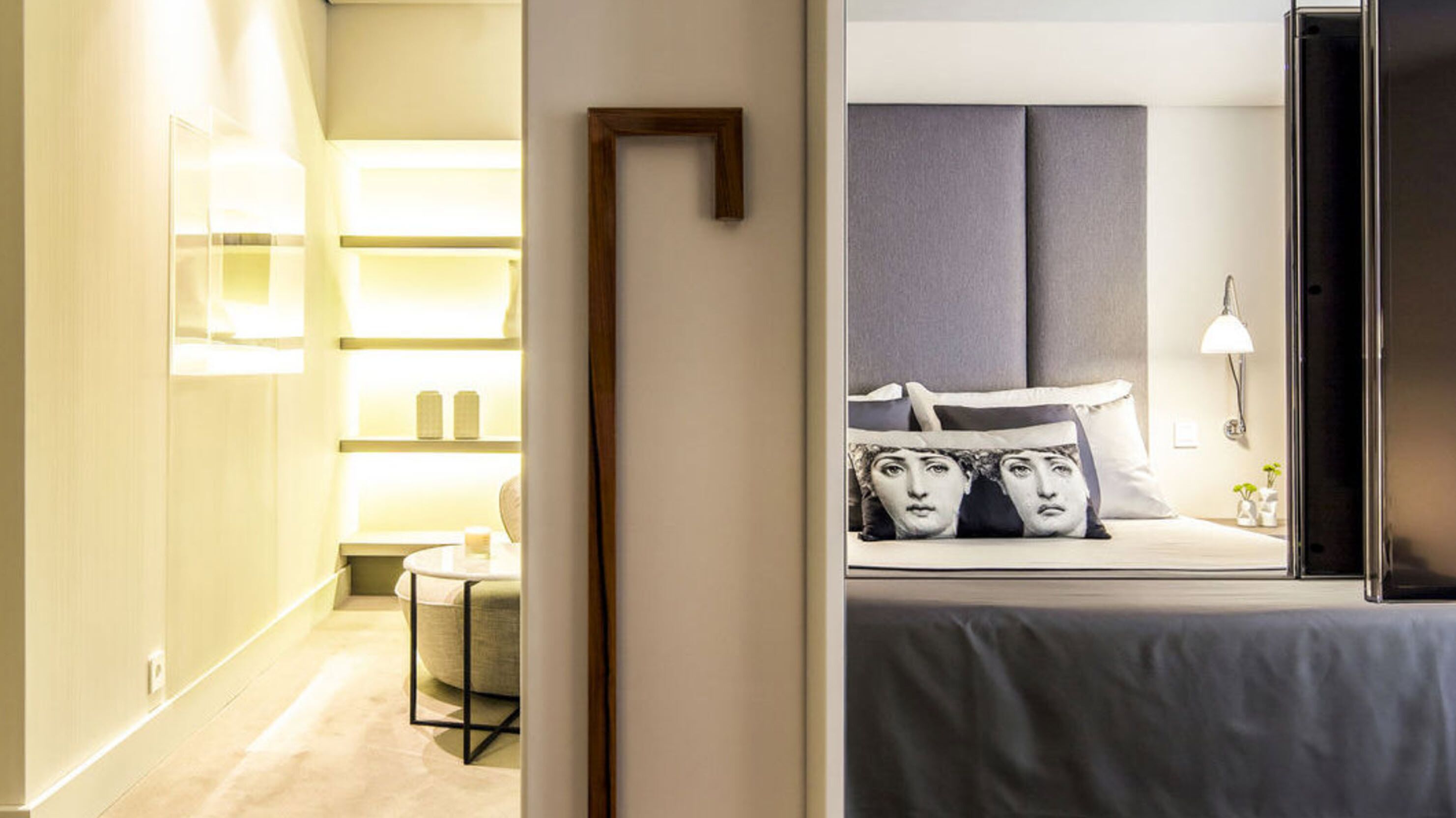 A hotel room with a bed, bedside table, and a nightstand.