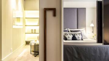 A hotel room with a bed, bedside table, and a nightstand.