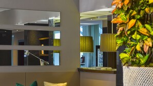 Un vestíbulo moderno con un sofá, sillas, una mesa de vidrio y una planta en maceta.