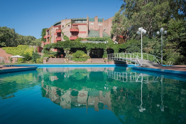 Una piscina techada, una piscina al aire libre de temporada, sombrillas