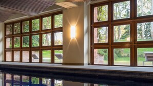 Una piscina con paneles de madera y grandes ventanales.