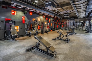 A gym with multiple benches and weight machines.
