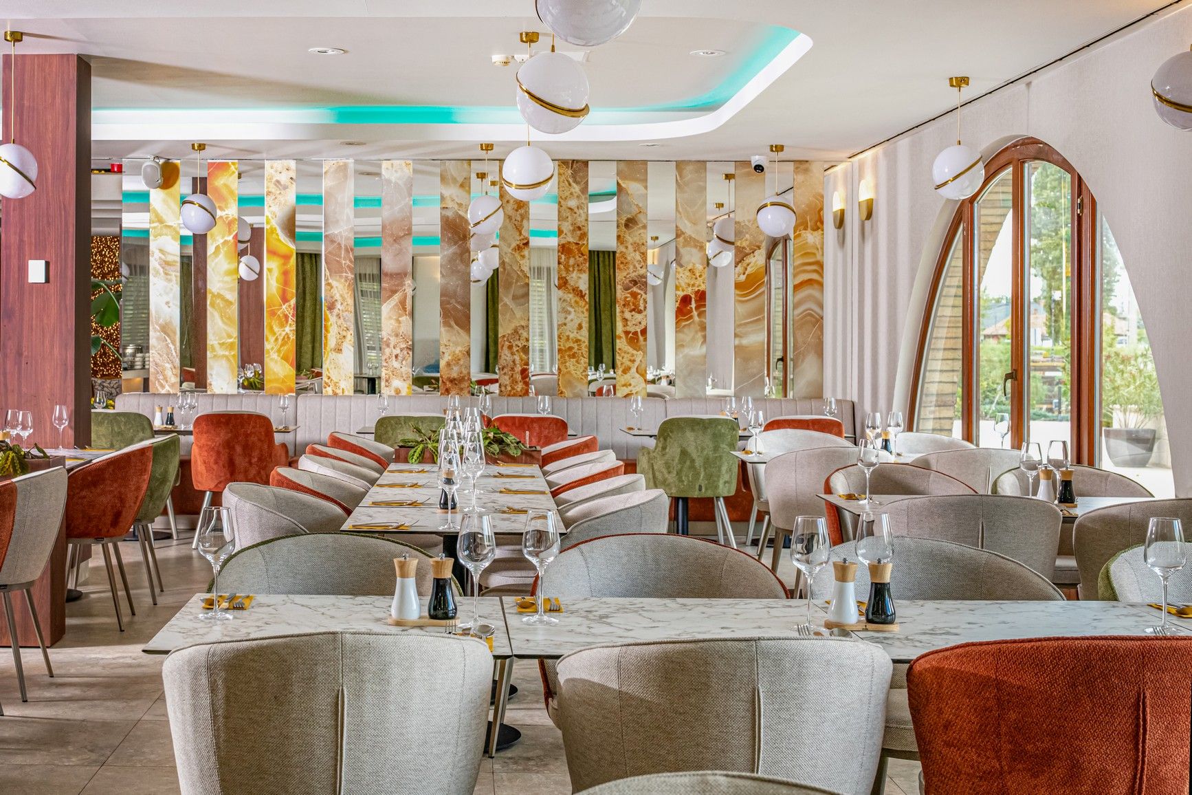 A restaurant with a long dining table, multiple chairs, and a modern interior design.