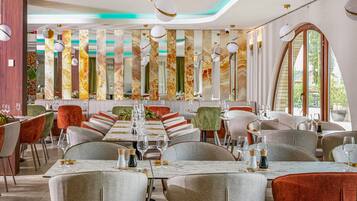 A restaurant with a long dining table, multiple chairs, and a modern interior design.