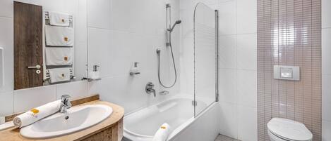 Et moderne badeværelse med en hvid vask, badekar og toilet.
