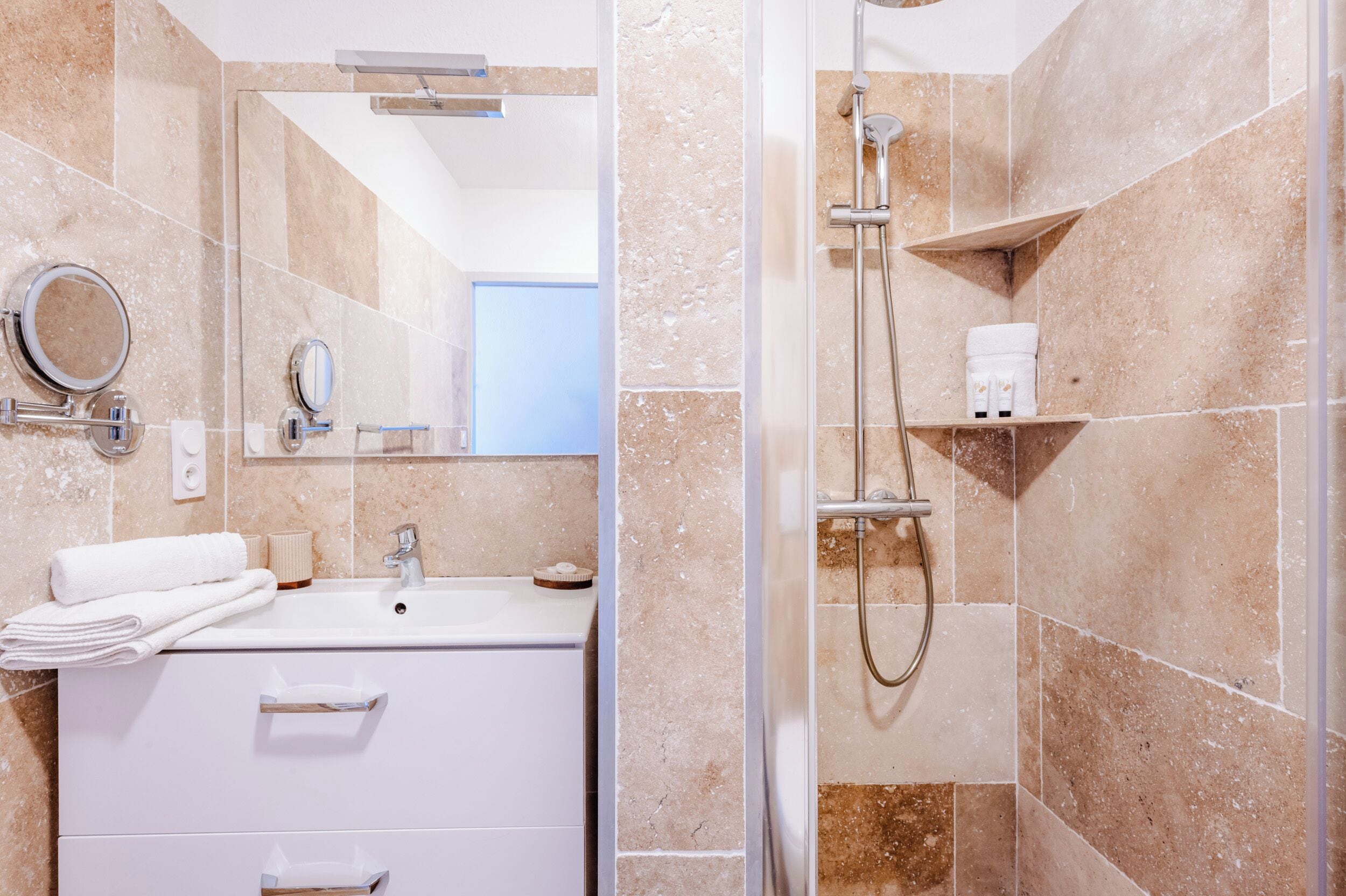 Ein Badezimmer mit Waschbecken, Spiegel und Dusche.