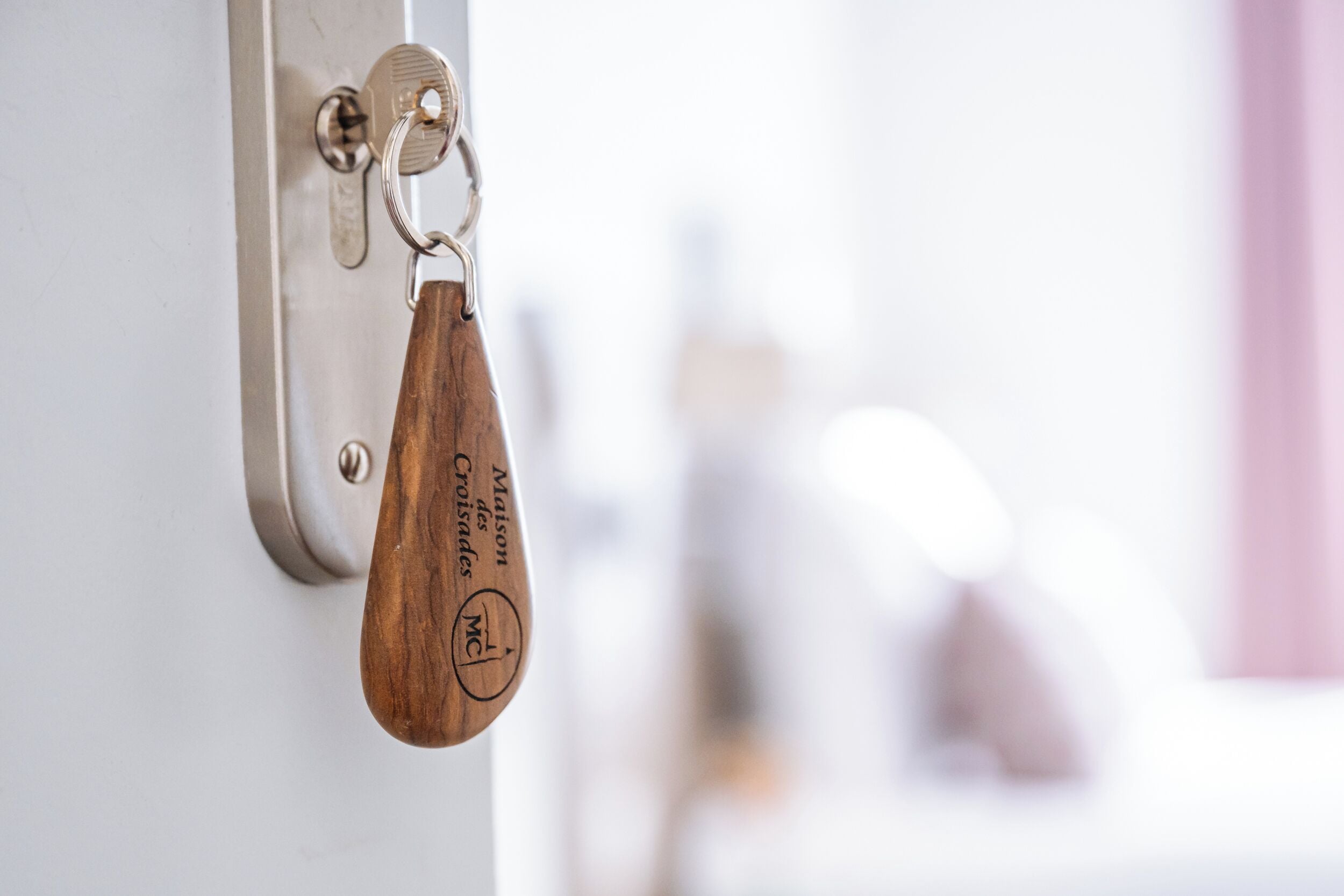 A door handle with a wooden keychain attached.