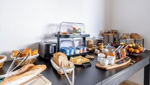 Un bufé de desayuno con pan, pastelería y diferentes mermeladas.