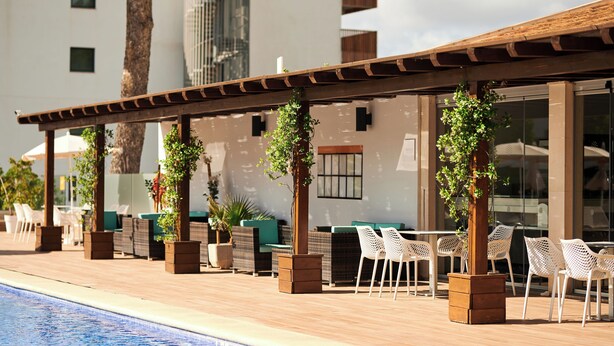 A poolside area with outdoor seating and a pergola. - Aluasun Continental Park Hotel & Apartments (Muro)